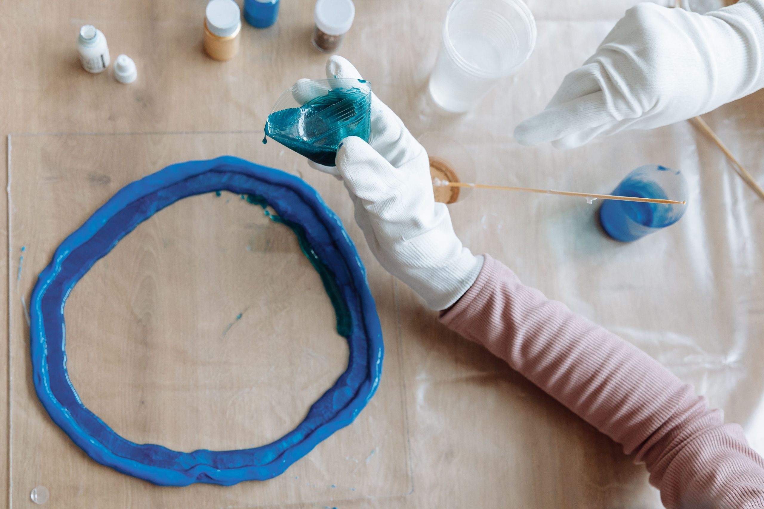 Mains créant une œuvre en résine bleue