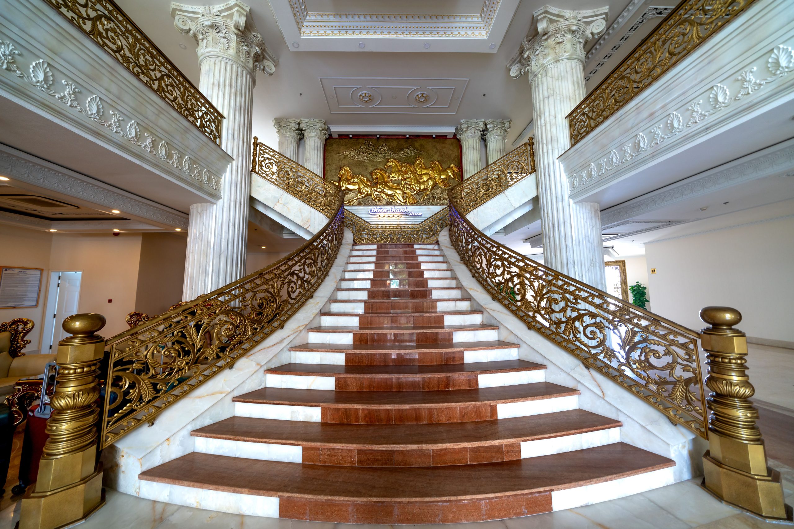 Escalier marbre élégant avec rampe dorée