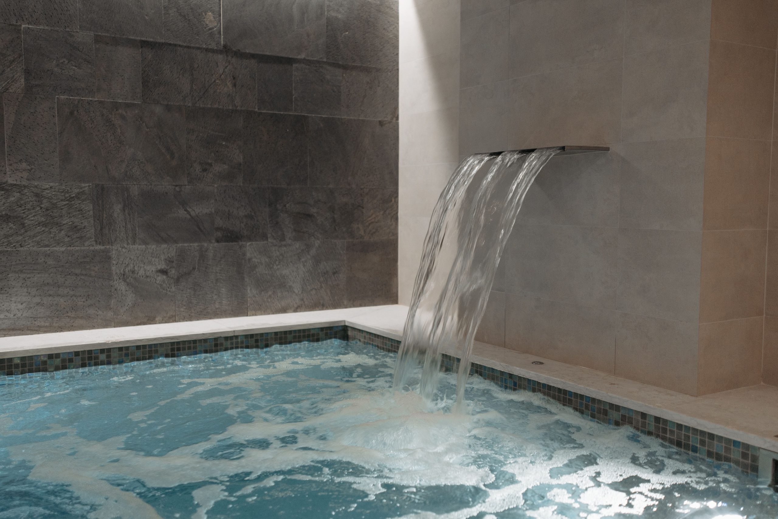 Piscine intérieure luxe marbre cascade spa