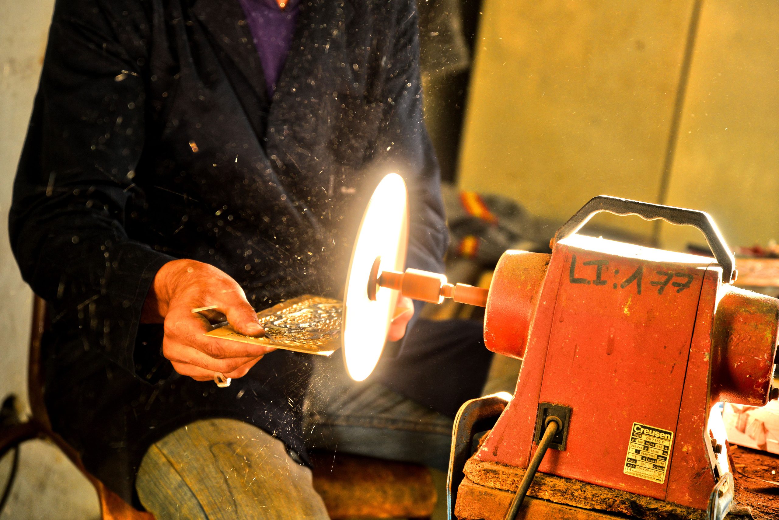 Artisan polissant marbre avec outil professionnel atelier