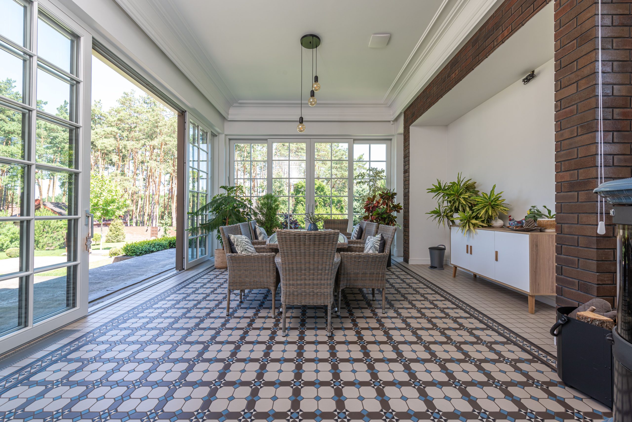 Véranda lumineuse avec carrelage motif et mobilier