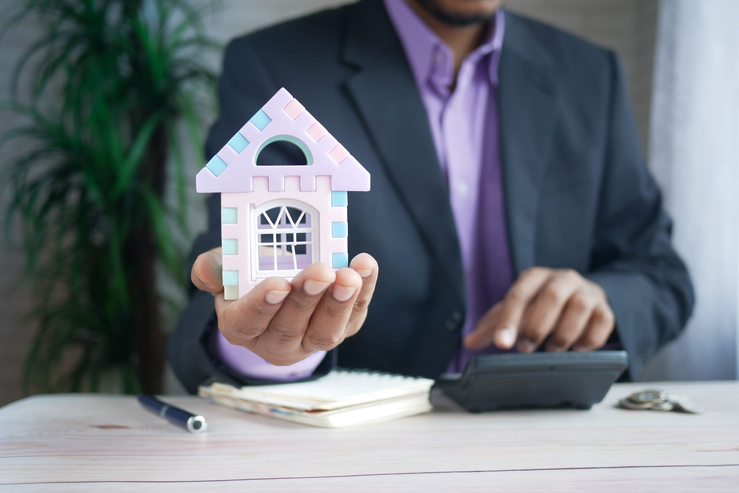 Homme d'affaires avec modèle maison calcule investissement