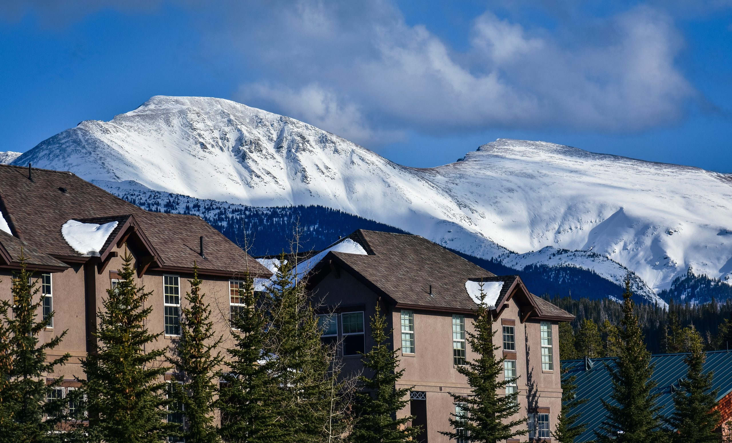 Maisons en hiver avec montagnes enneigées en arrière-plan