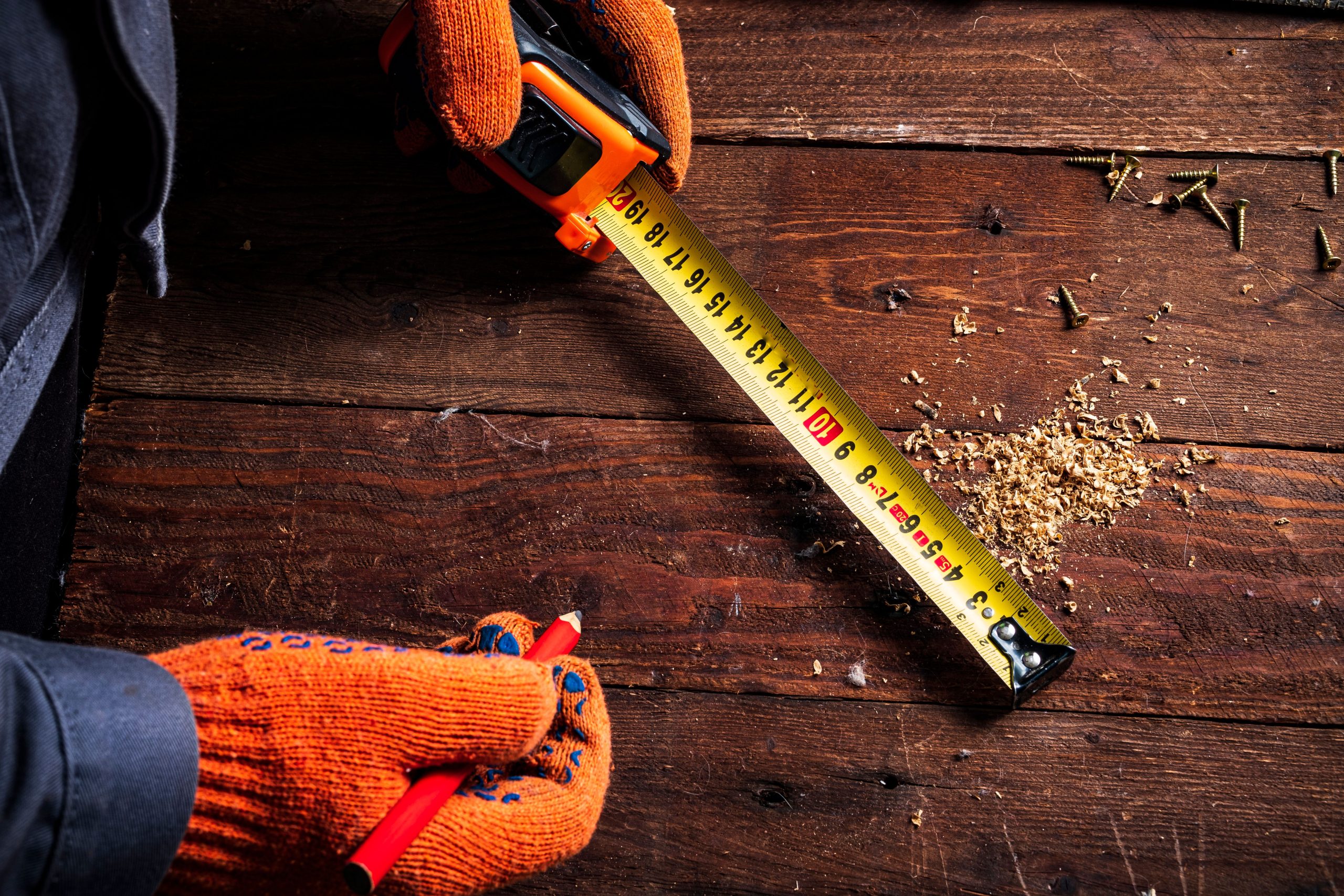 Mains gantées mesurant surface bois précision