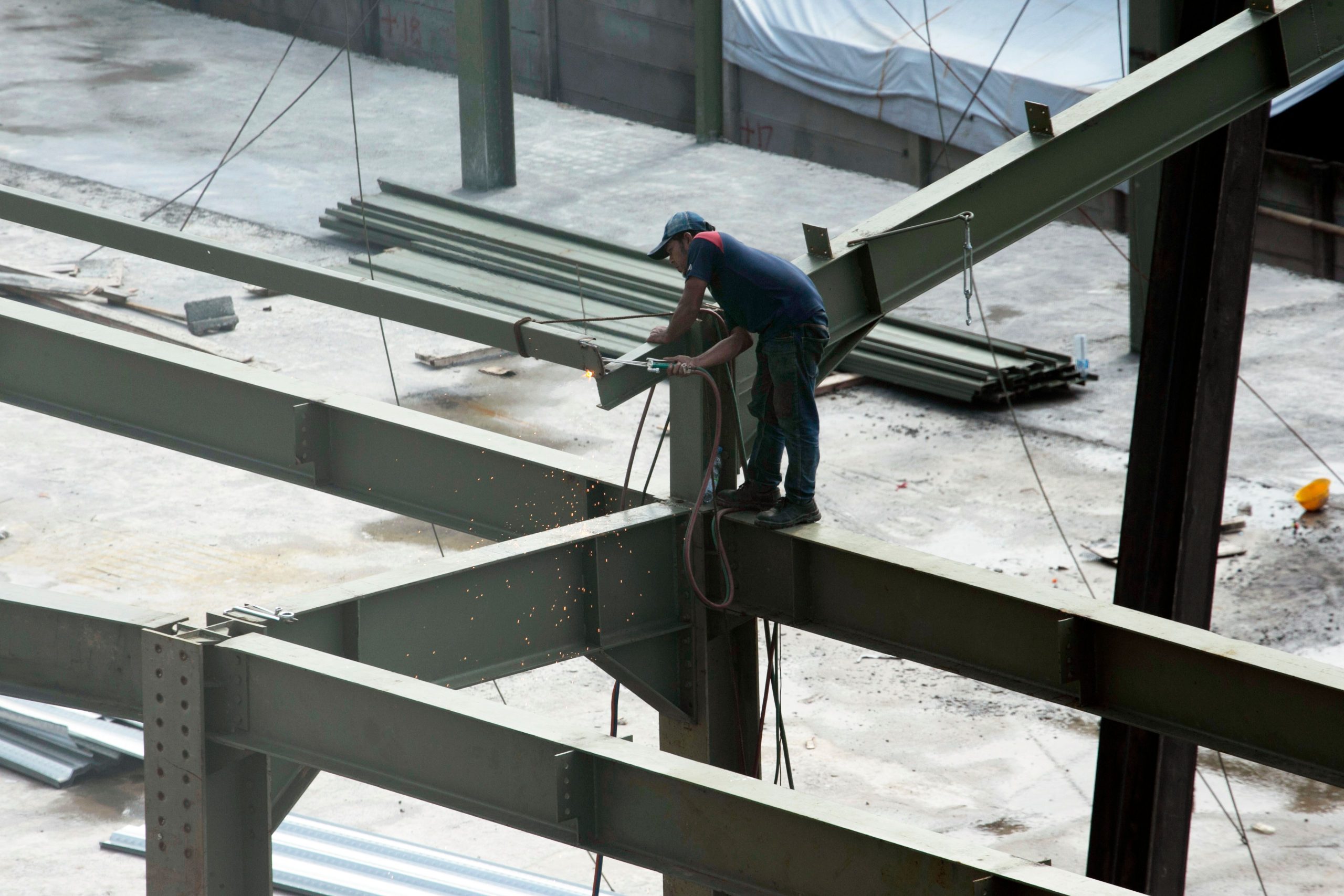 Ouvrier soudant des poutres sur chantier haute.