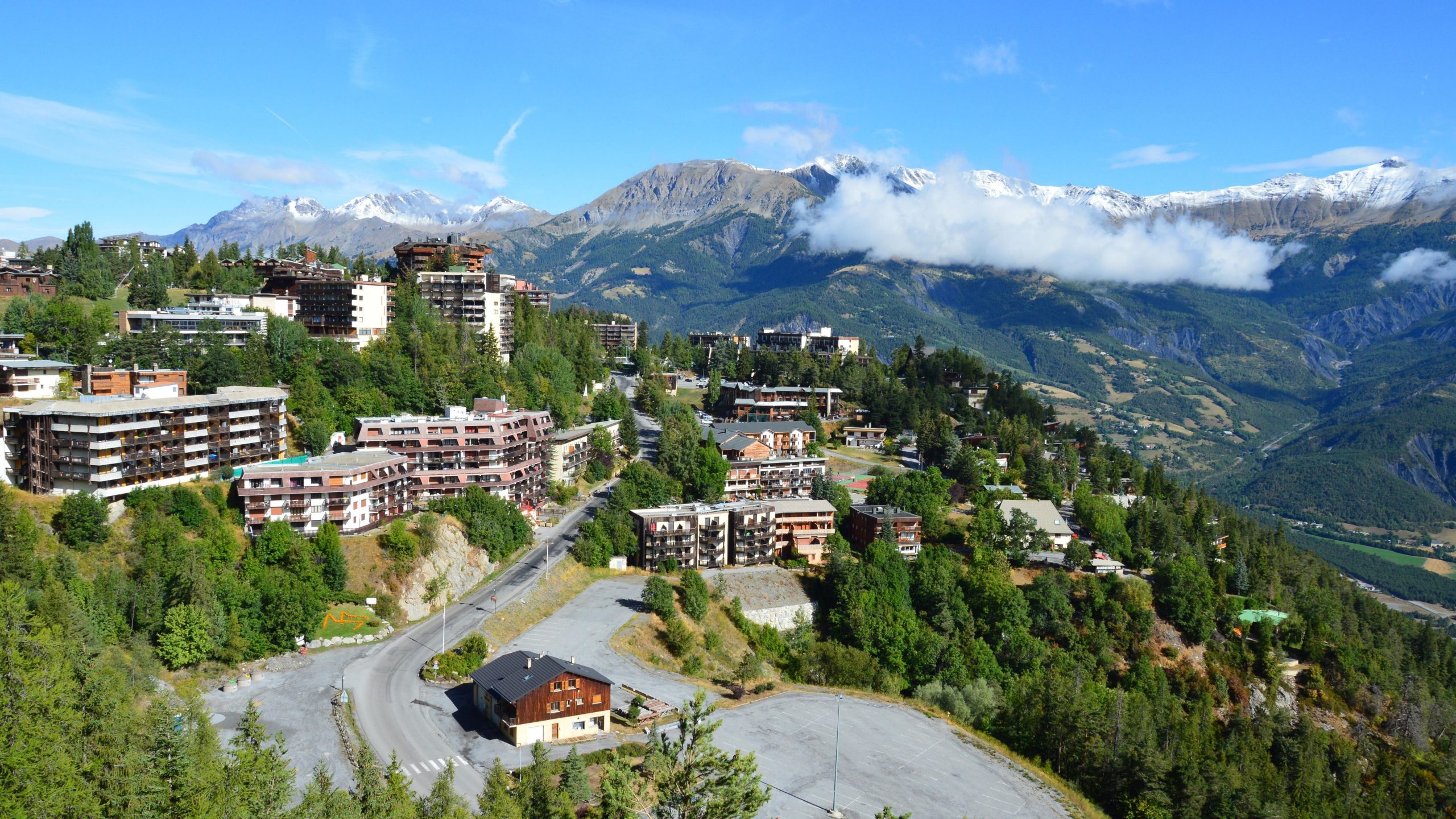 Village de montagne aérien niché dans la verdure alpine