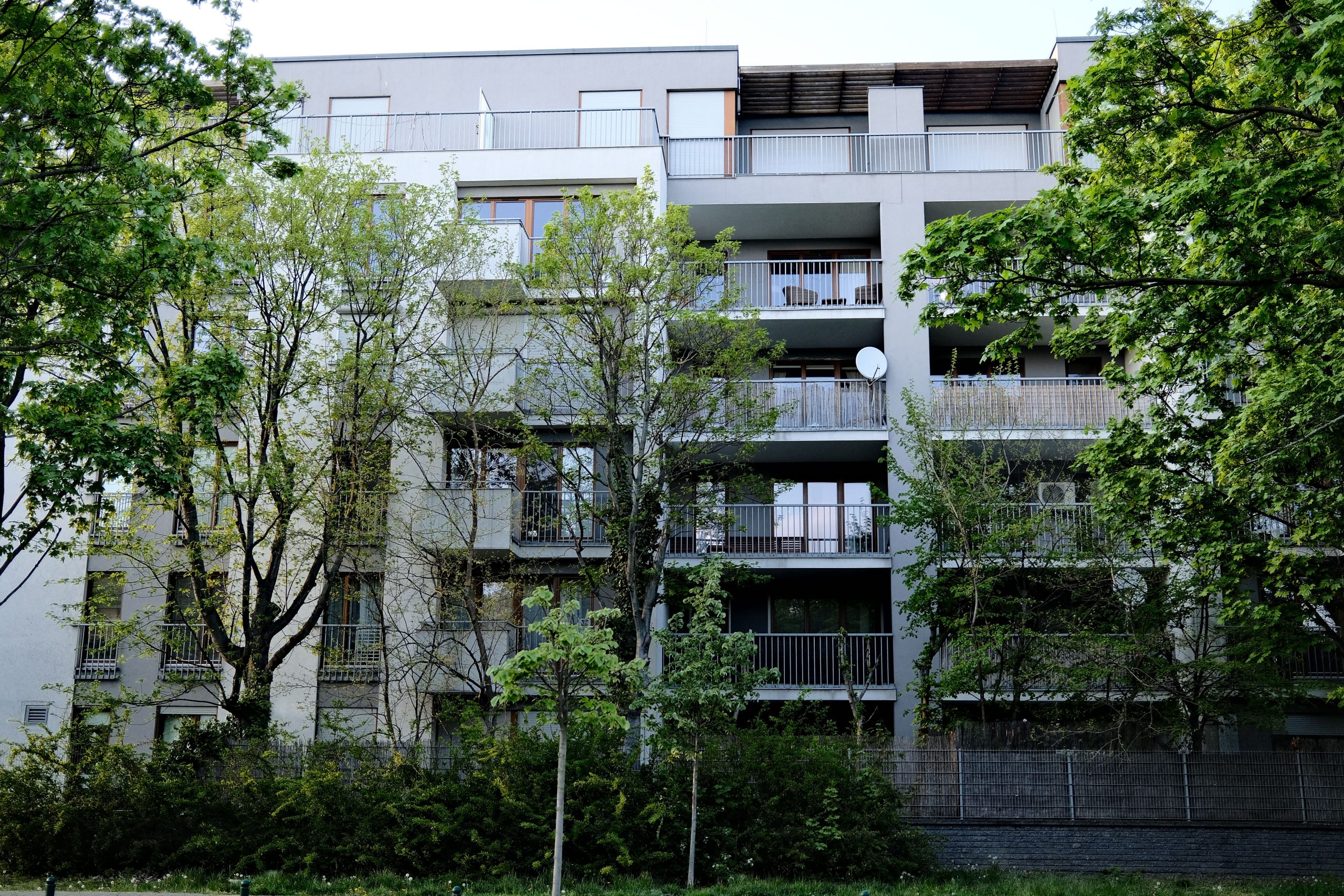 Immeuble urbain entouré de verdure et arbustes