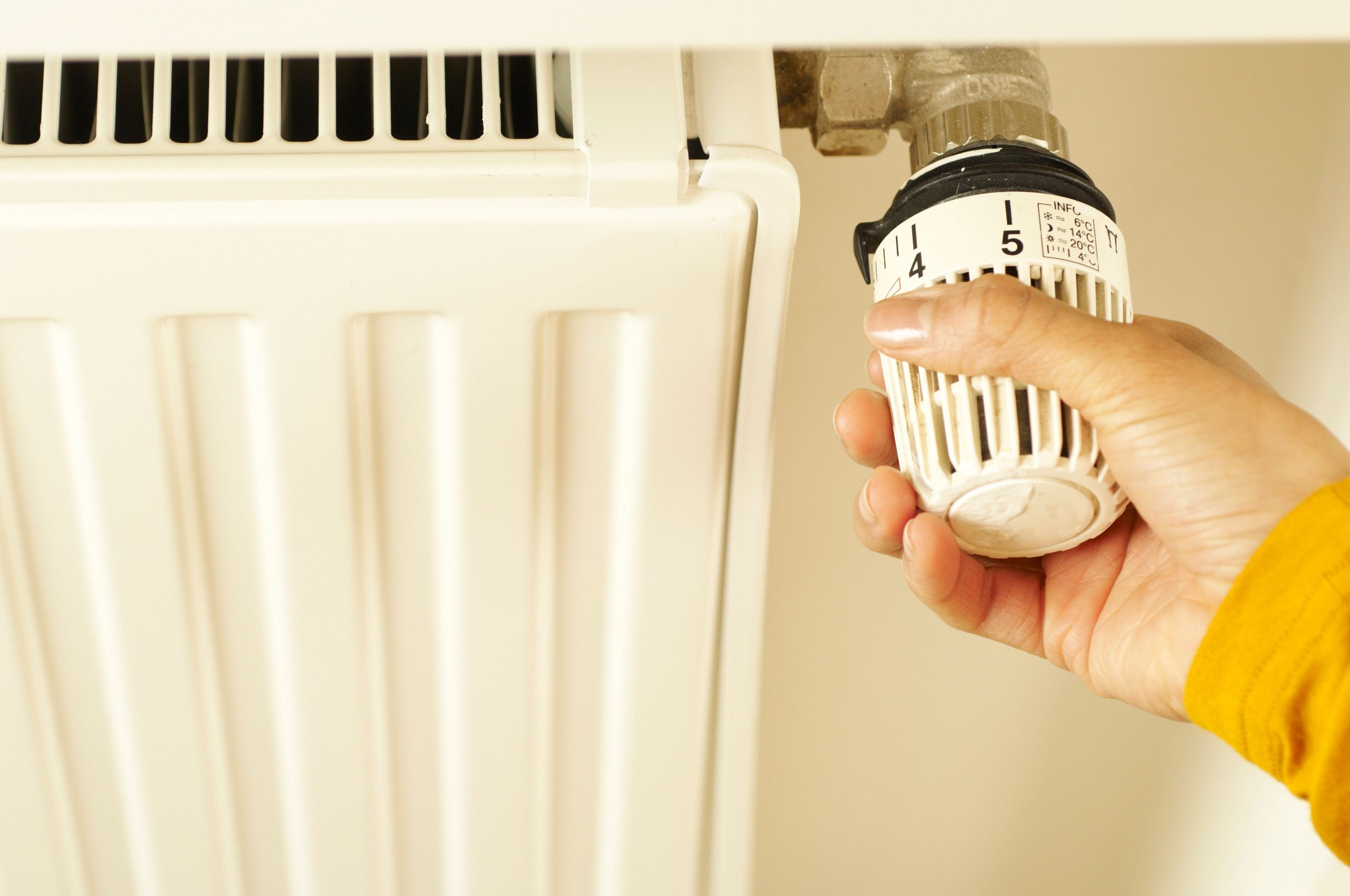 Main ajustant un thermostat de radiateur